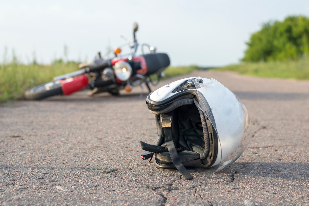 Foto de casco y motocicleta en la carretera, el concepto de accidentes de tráfico.