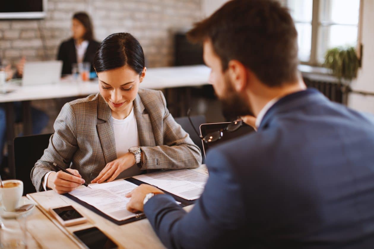 Joven firma un contrato de trabajo.