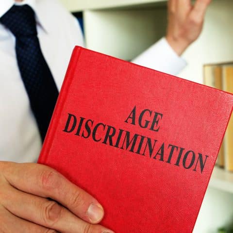Un abogado muestra un libro sobre la ley de discriminación por edad en la oficina.