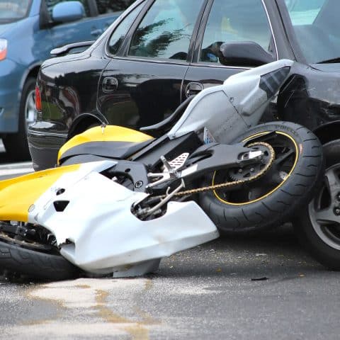 Accidente de coche y moto al aire libre.