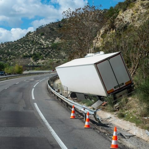 Camión frigorífico que ha sufrido un accidente al salirse de la carretera, dejándolo fuera de la carretera pero sin volcar.