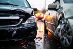 Vista en primer plano de un accidente de coche en una carretera mojada durante la lluvia.