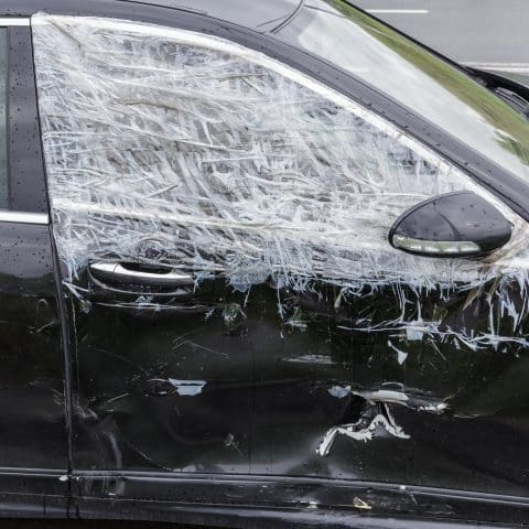 Ventana rota en el lado del pasajero. Una ventana de automóvil rota después de un robo por parte de un ladrón. Vandalismo.