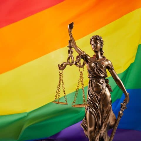 La diosa de la justicia, Themis, con los ojos vendados, contra la bandera del arcoíris LGBT. Derechos LGBT y la ley.